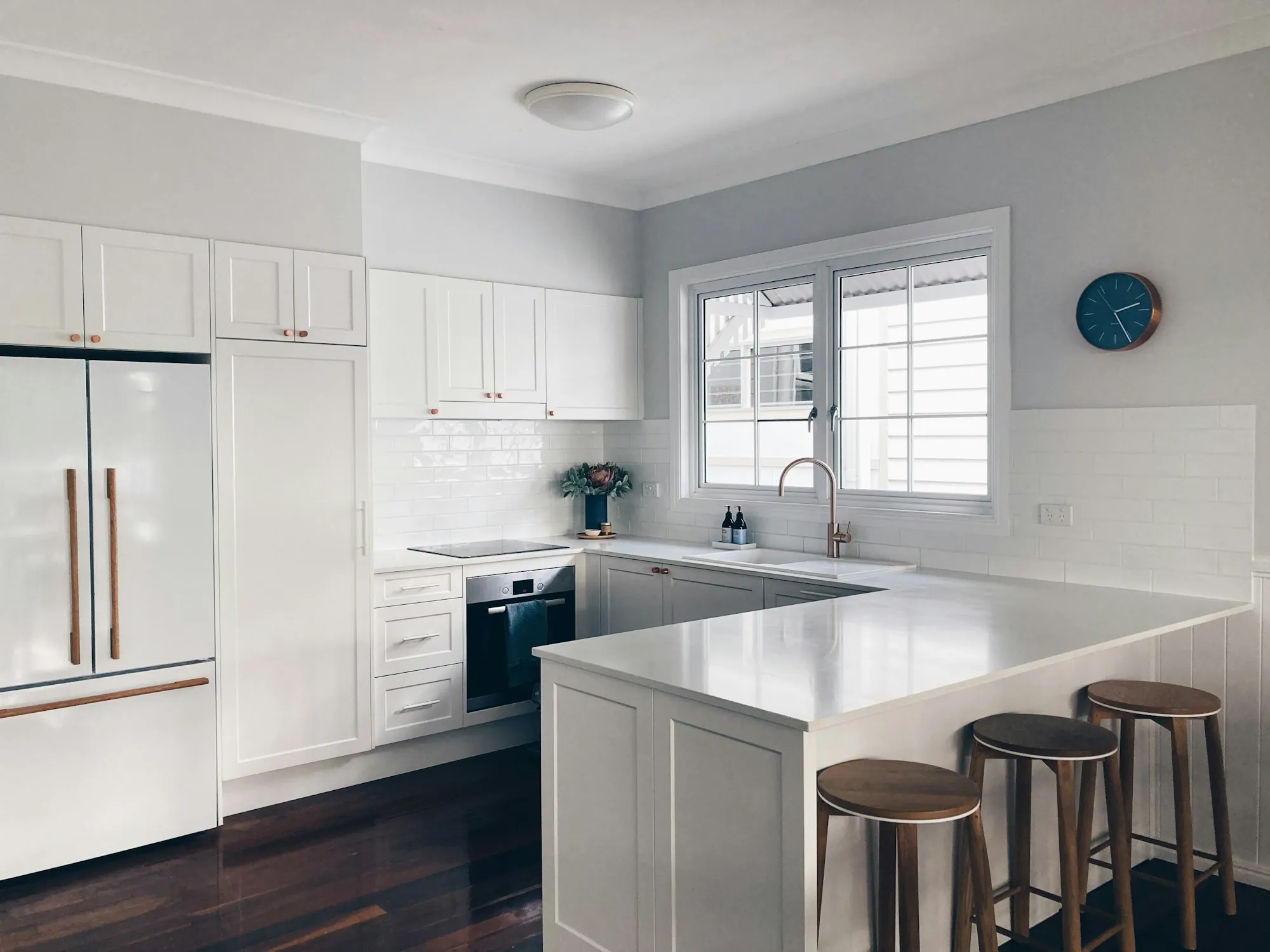 White kitchen with a peninsula and bar stools